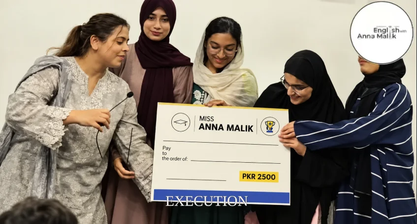 Anna Malik presenting a recognition cheque with students